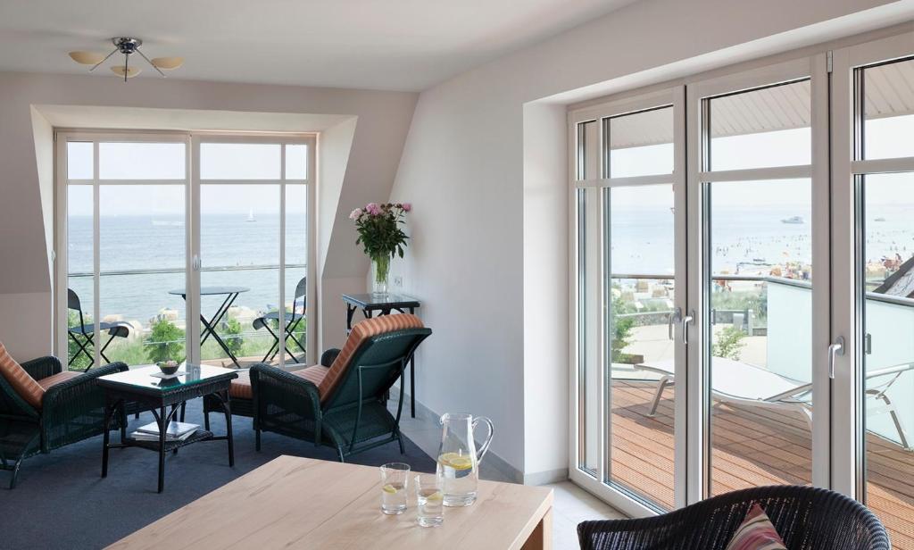 a living room with a table and chairs and a balcony at Albatros in Haffkrug