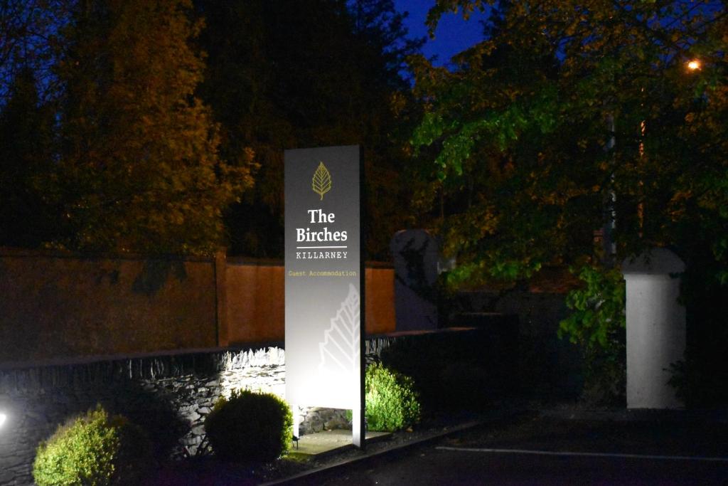 a sign in front of a building at night at The Birches Killarney in Killarney