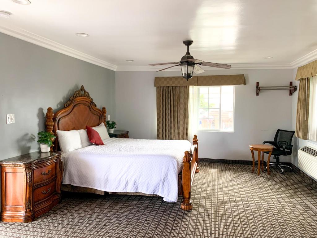 文圖拉的住宿－Viking Motel-Ventura，一间卧室配有一张大床和吊扇
