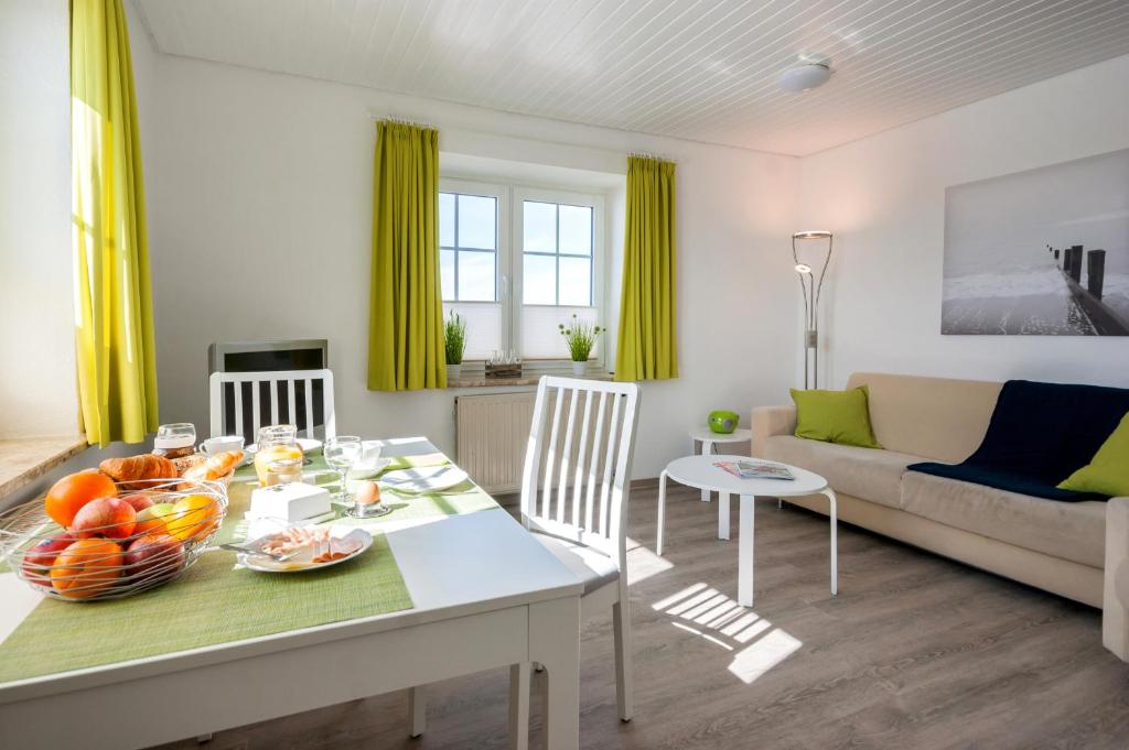Il comprend une cuisine et un salon avec une table et des chaises. dans l'établissement Knusthof Lafrenz - Küstenblick, à Fehmarn