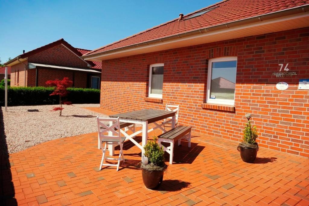a picnic table and two chairs on a brick patio at Feriendomizil Bellevue in Walchum