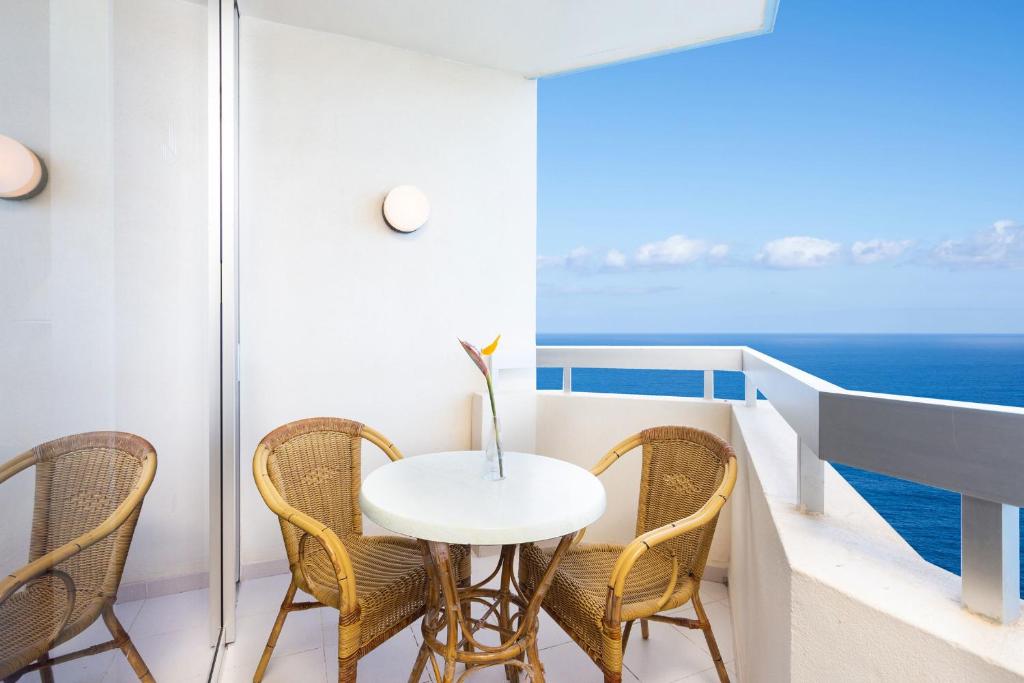 プエルト・デ・ラ・クルスにあるStudio 1509 im Precise Resort Tenerifeの海を望むバルコニー(テーブル、椅子付)