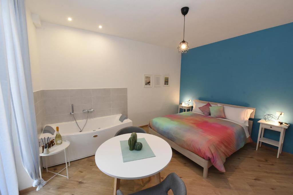Geordie's في بوتنزا: غرفة نوم مع سرير وحوض استحمام وطاولة