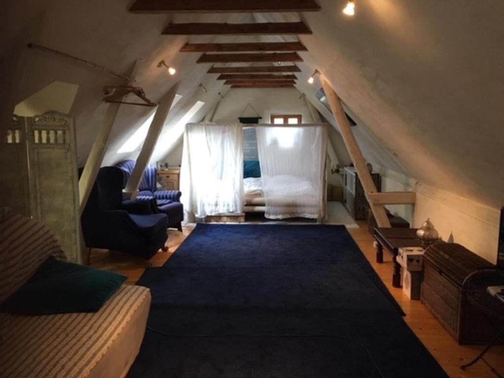 a attic room with a bed and a staircase at Grosse Hobbithöhle mit Gemeinschaftsgarten in Neustadt am Rübenberge