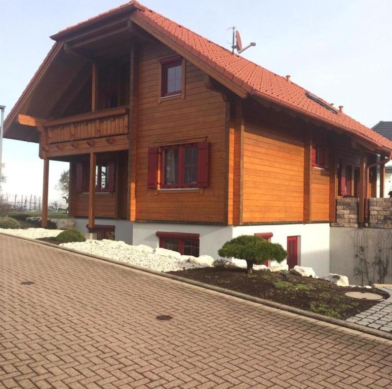 ein Holzhaus mit rotem Dach auf einer Backsteinstraße in der Unterkunft Braunkehlchen in Straubenhardt