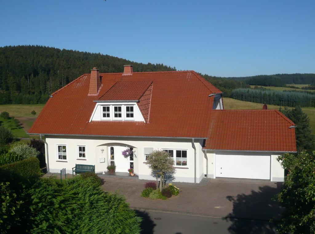 a white house with a red roof at Ferienwohnung Leitges in Bettenfeld