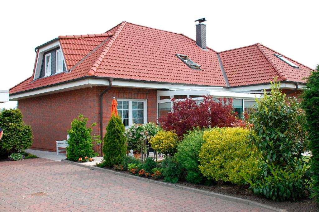 una casa con tetto rosso su una strada di mattoni di Privatzimmer Ehrhardt Nr1 a Burg auf Fehmarn