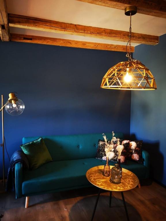 a living room with a green couch and a table at BLUMENSTIL Ferienwohnungen 3 in Bad Salzungen