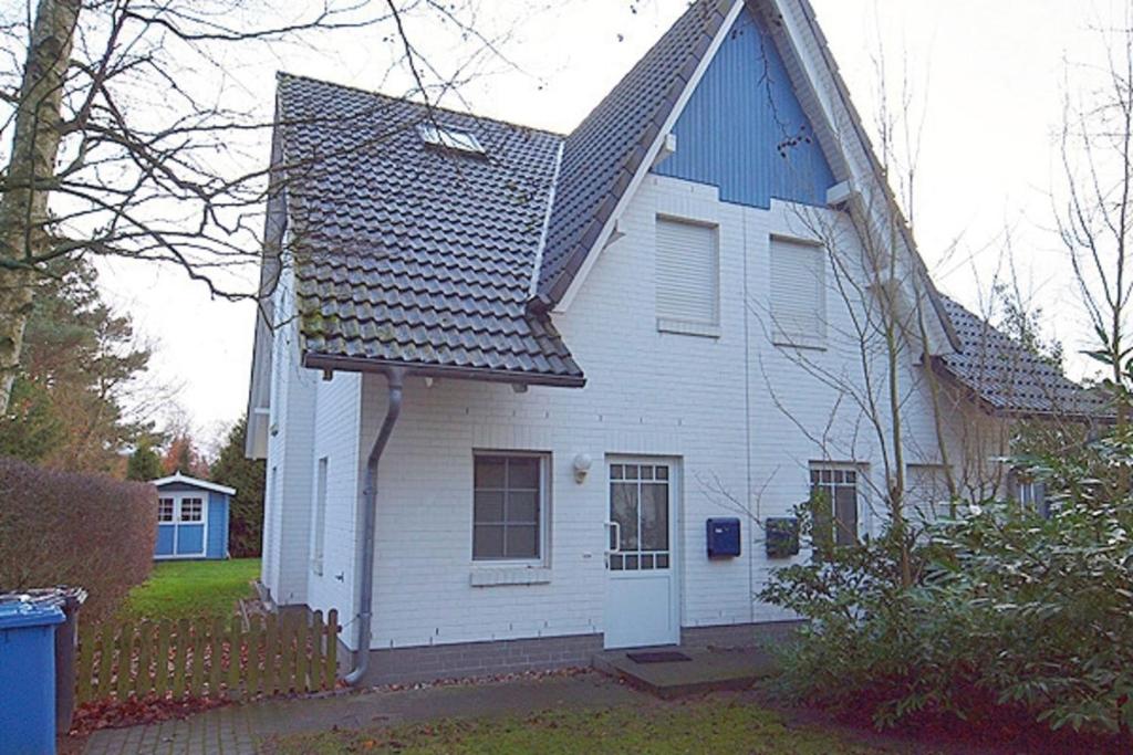 uma casa branca com um telhado azul em Strandbiene em Zingst