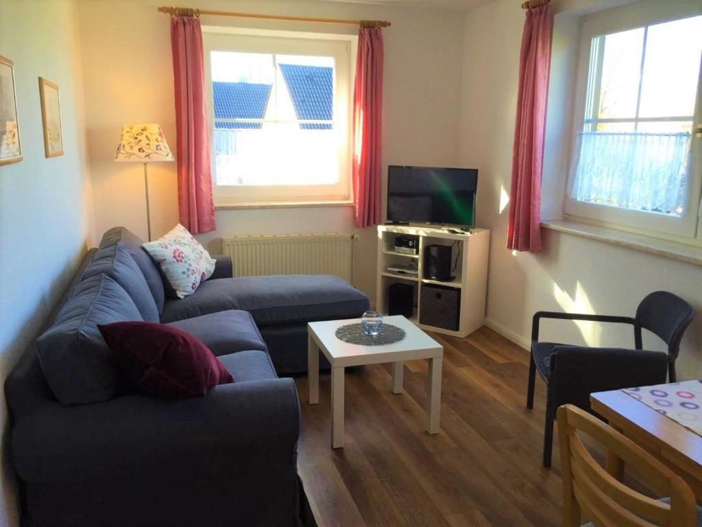 a living room with a blue couch and a table at Ferienwohnung 7, OG, Hof zur Sonnenseite Fehmarn in Fehmarn