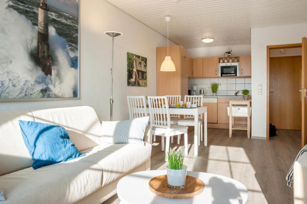 フェーマルンにあるKnusthof Lafrenz - Sundblickのリビングルーム(白いソファ付)、キッチンが備わります。