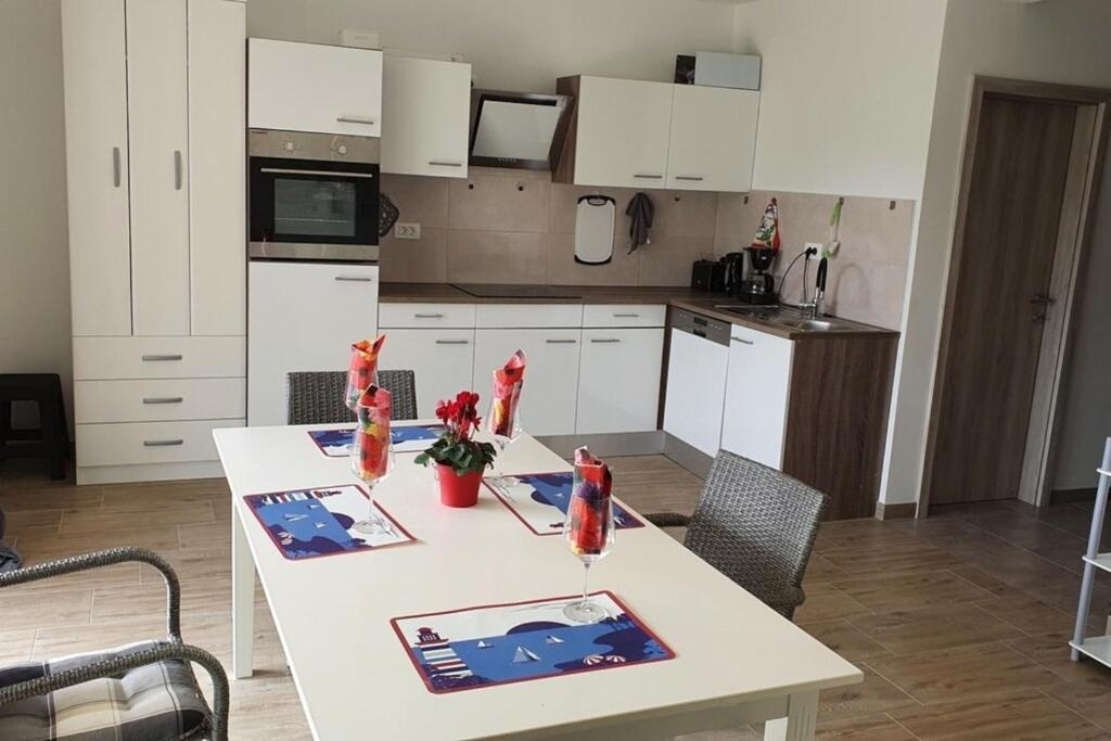 a kitchen with a white table and a kitchen with white cabinets at Olivia Valkanela App 1 in Vrsar