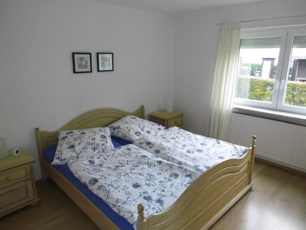 a bedroom with a bed with a blue and white comforter at Ferienwohnung "Strand Hus 1" in Heiligenhafen