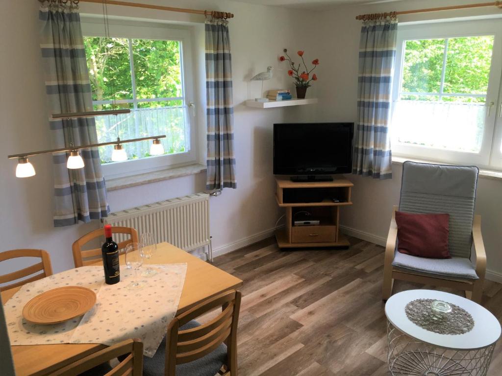 a living room with a table and a tv at Ferienwohnung 5, OG, Hof zur Sonnenseite Fehmarn in Sahrensdorf