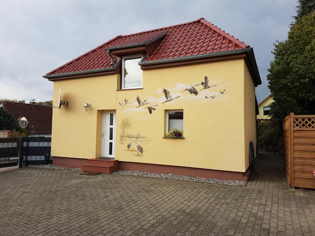 uma casa com pássaros pintados ao lado dela em Heublein em Poseritz