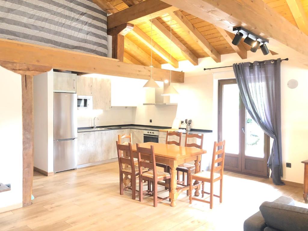 cocina y comedor con mesa de madera y sillas en Urruti en Zilbeti