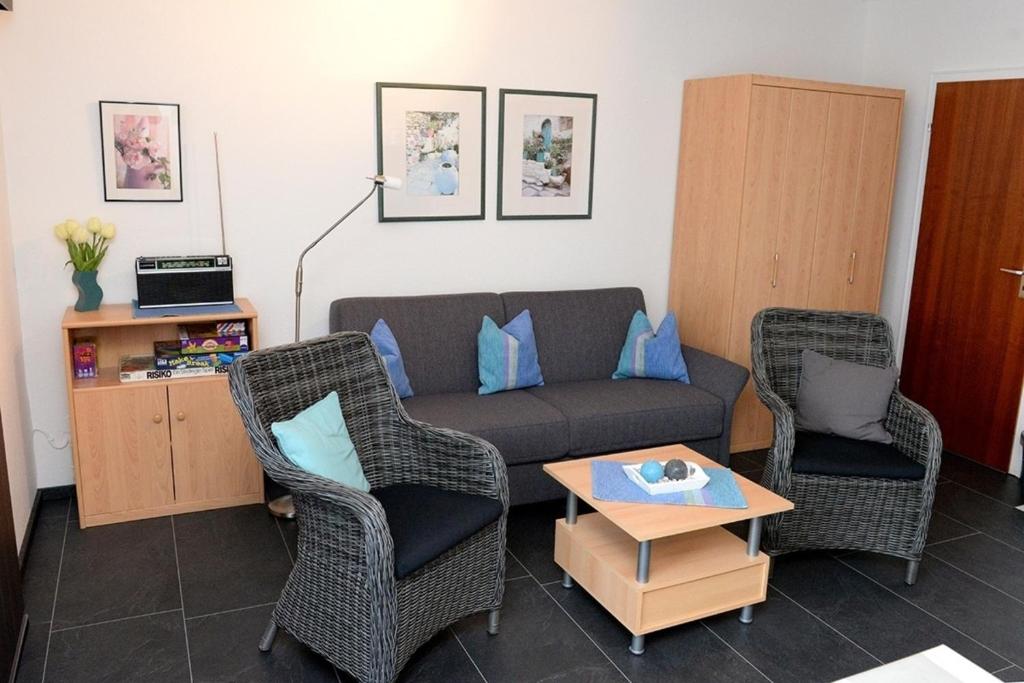 uma sala de estar com um sofá e duas cadeiras em Fewo 91 WHG A 5 in Burhave em Burhave