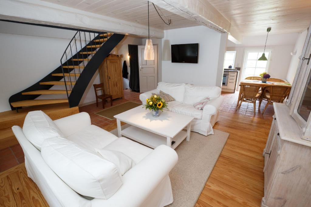 Il comprend un salon doté d'un mobilier blanc et d'un escalier. dans l'établissement Stall, à Borgsum