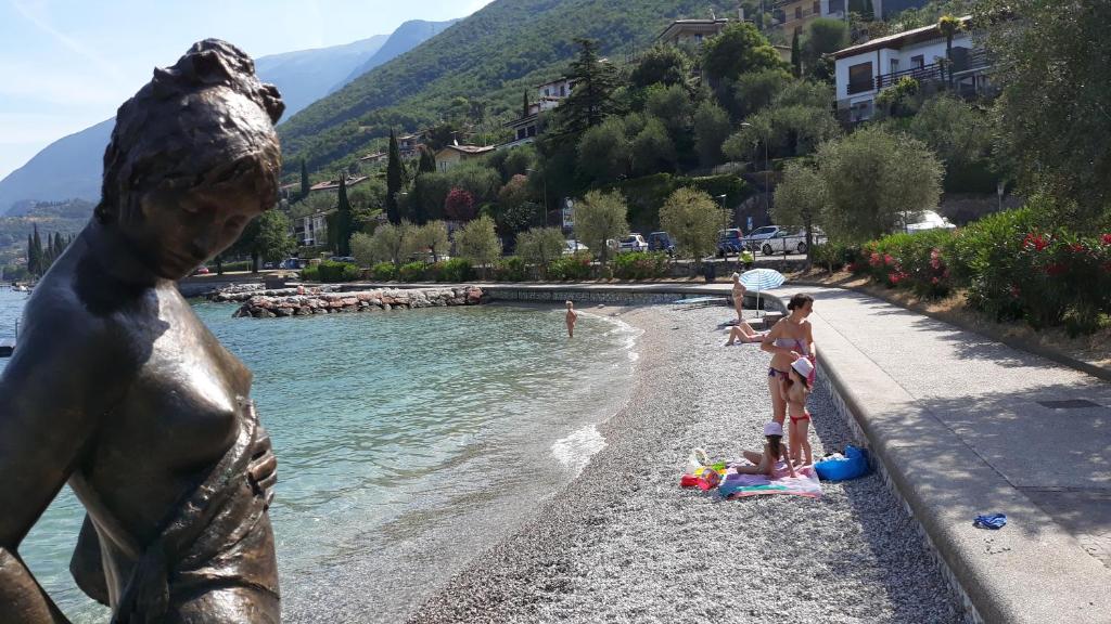 a group of people on a beach with a statue at Dependance in Malcesine