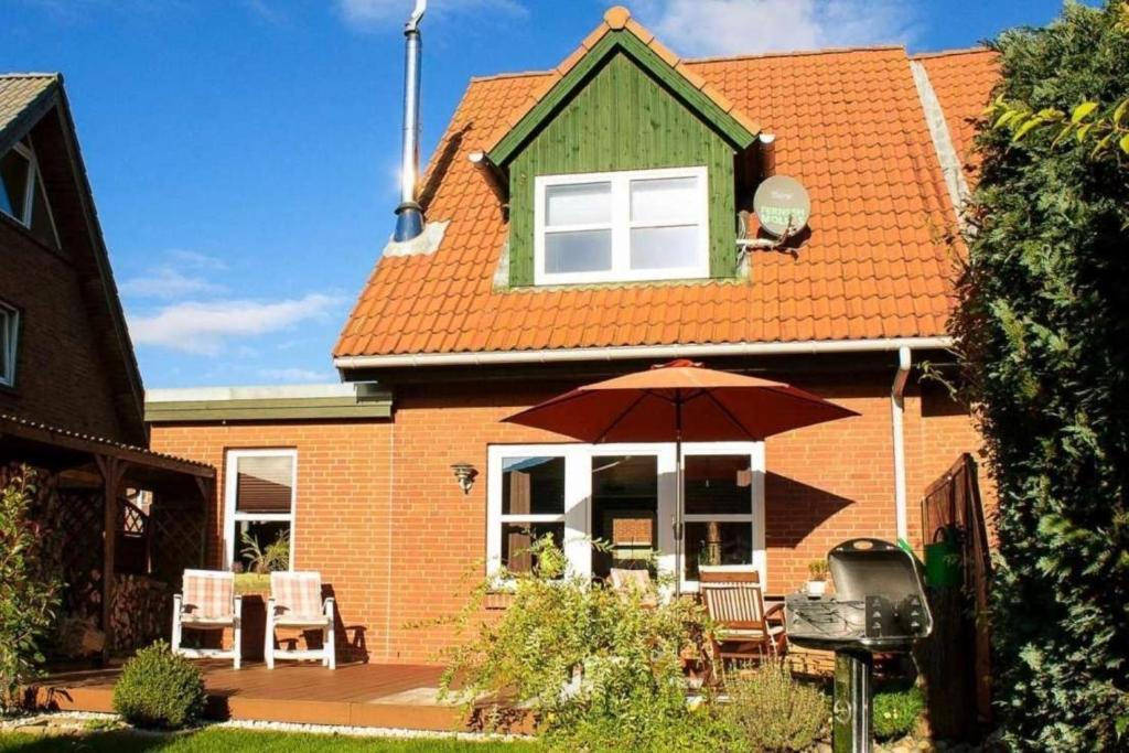 uma casa com um guarda-chuva em frente em Haus Sonnenschein em Dänschendorf