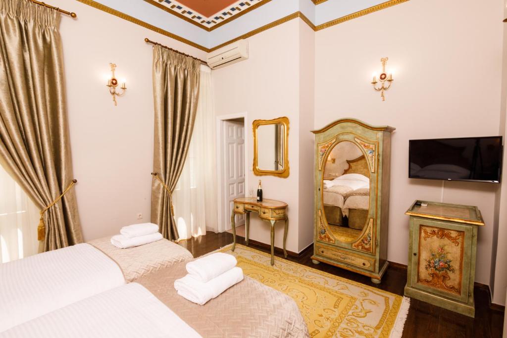 A bed or beds in a room at Palaiologos Luxury City Hotel