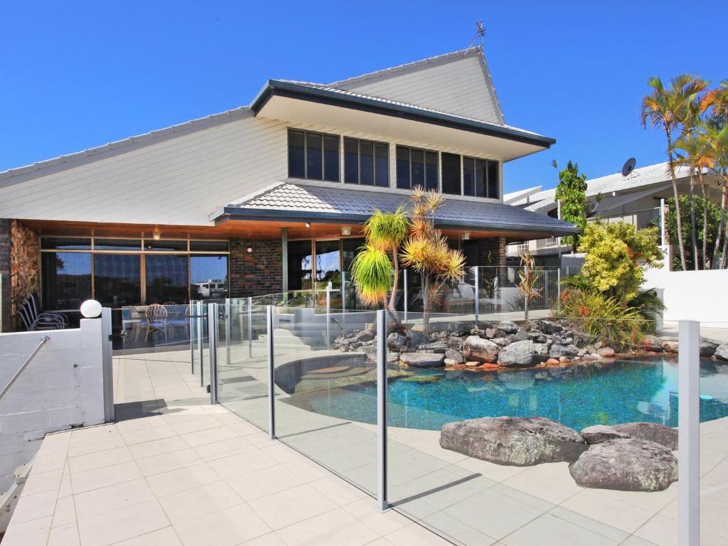 a house with a swimming pool in front of a house at Yulunga 20 in Mooloolaba