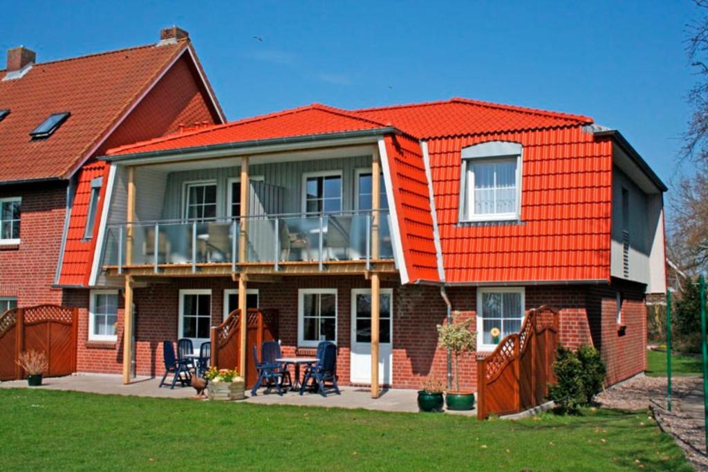 a house with an orange roof and a balcony at "Landhaus Voss" Typ 2 Nr5 in Staberdorf