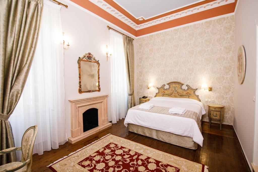 Postel nebo postele na pokoji v ubytování Palaiologos Luxury City Hotel
