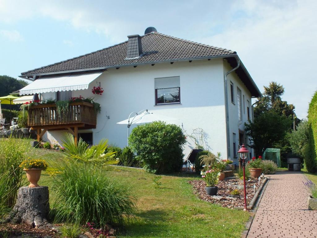 uma casa branca com uma varanda em Ferienwohnung Iris em Fritzlar