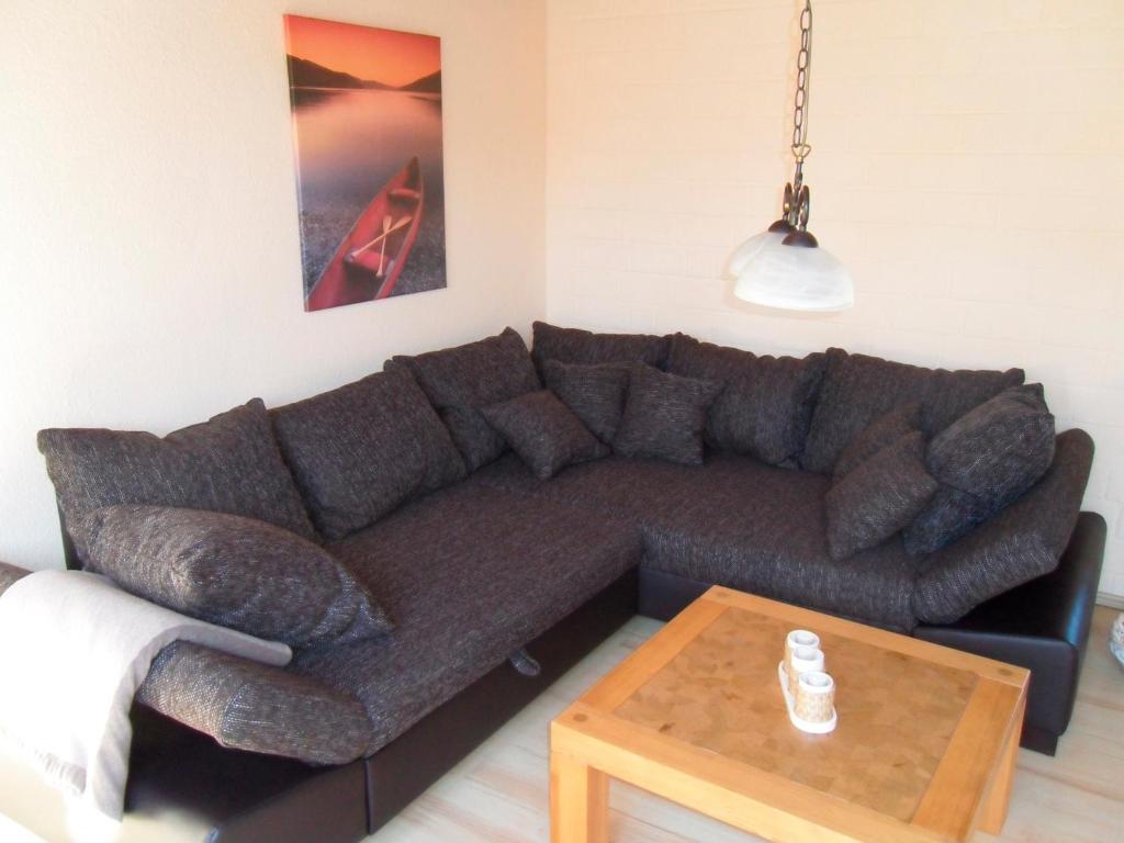 a living room with a brown couch and a table at Ferienwohnung Schulz in Heiligenhafen