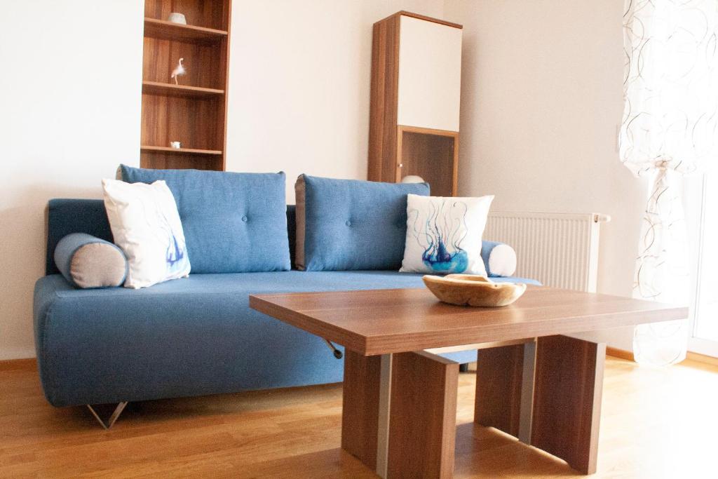 a living room with a blue couch and a wooden table at Royal 4 Trend by Alpenidyll Apartments in Liezen