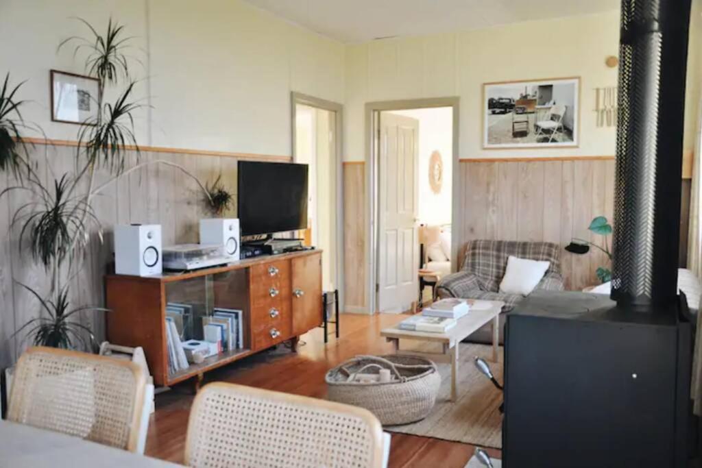 a living room with a couch and a tv at The Shack at Skenes Creek in Apollo Bay