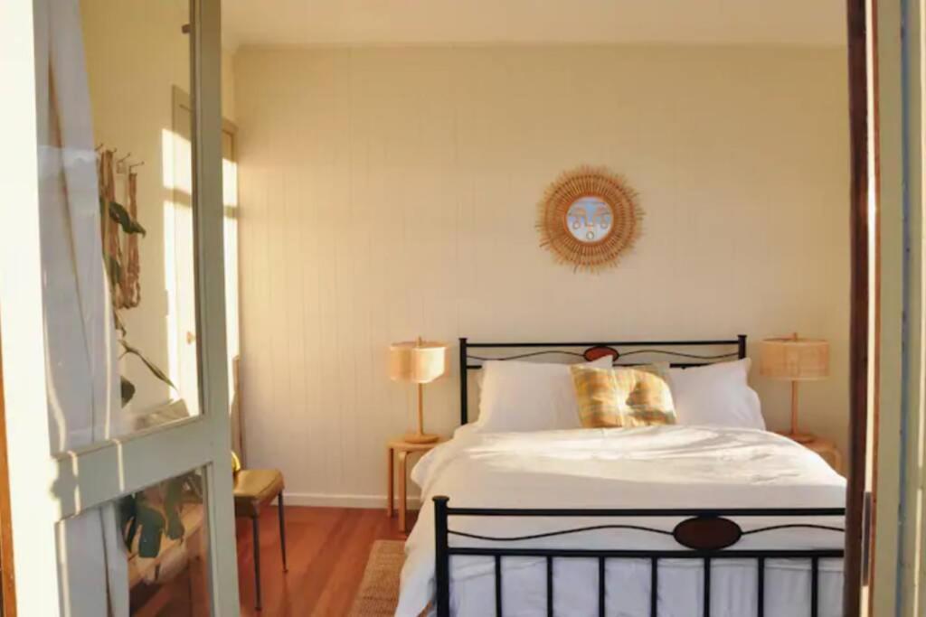 a bedroom with a bed and a clock on the wall at The Shack at Skenes Creek in Apollo Bay