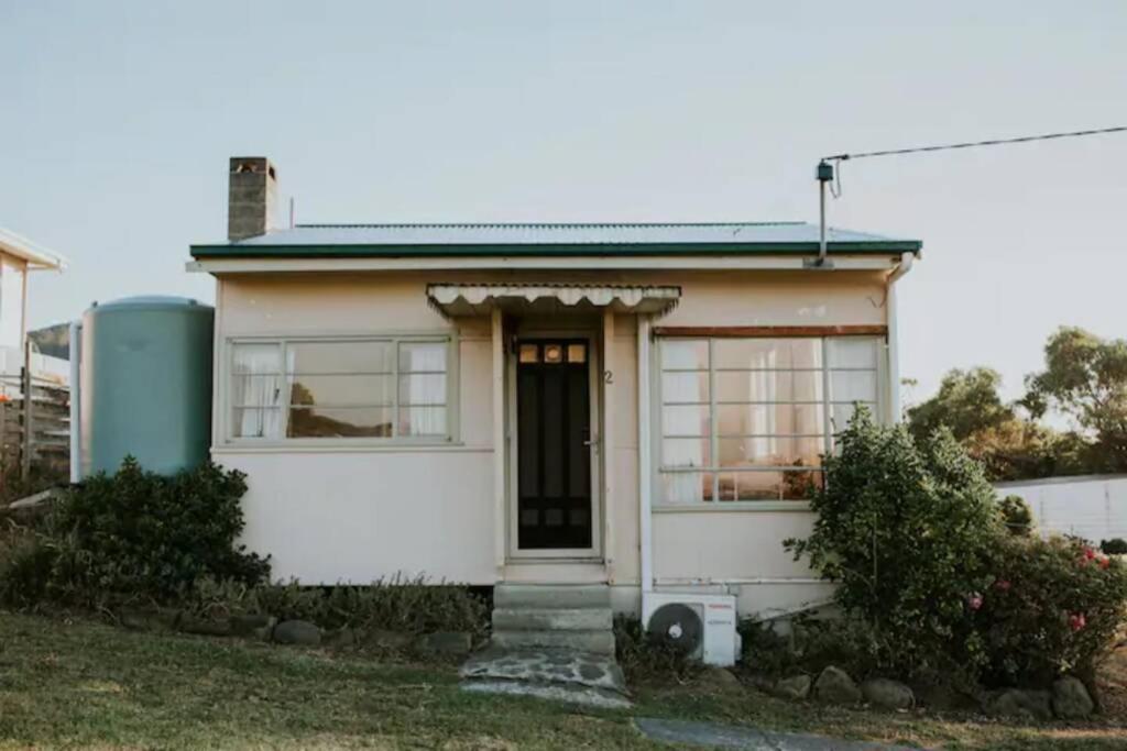 a small white house with a door and windows at The Shack at Skenes Creek in Apollo Bay