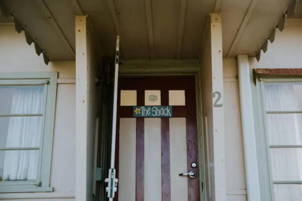 a front door of a building with a sign on it at The Shack at Skenes Creek in Apollo Bay