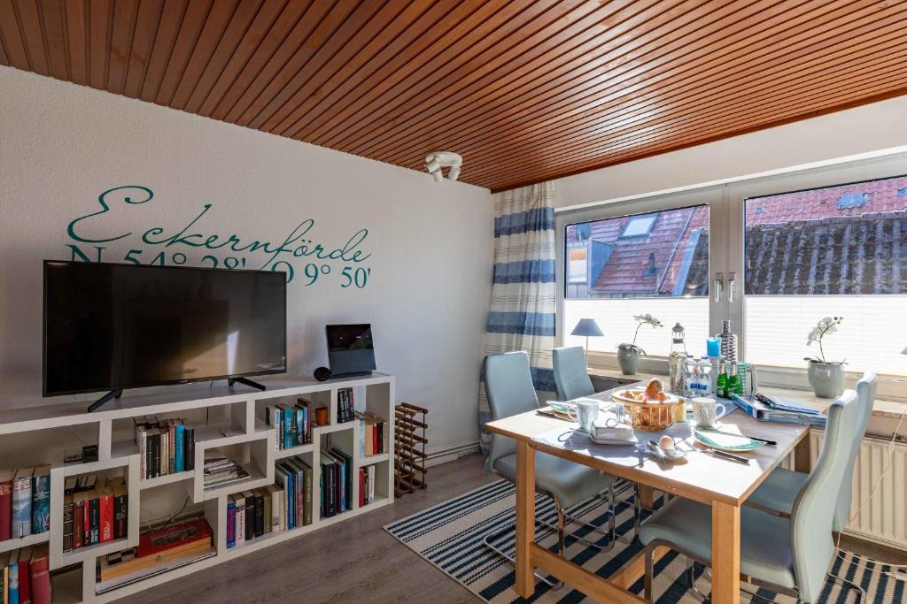 uma sala de jantar com uma mesa e uma televisão em Haus zum Seiltänzer - Oberdeck em Eckernförde