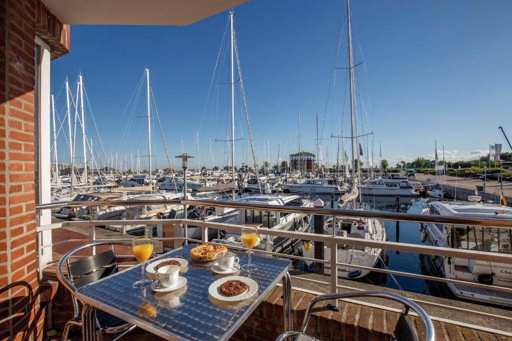 a table on a balcony with a marina with boats at ancora Marina Haus 1 Nr 04, Typ 2 in Neustadt in Holstein