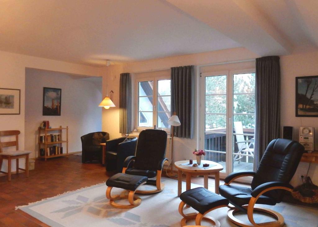 sala de estar con sillas, mesa y ventanas en Resi E06 en Prerow