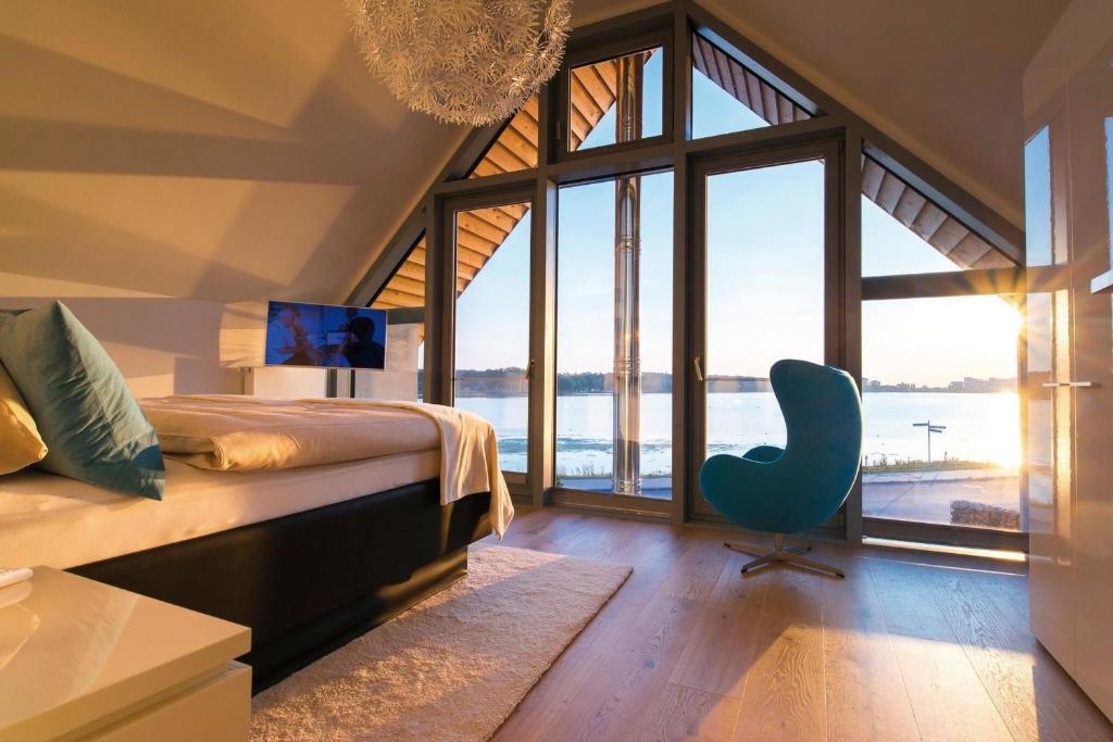 ハイリゲンハーフェンにあるOstsee - Reetdachhaus Nr 3 "Südstrand Lodge Marina-Bay" im Strand Resortのベッドルーム1室(ベッド1台、デスク、椅子付)
