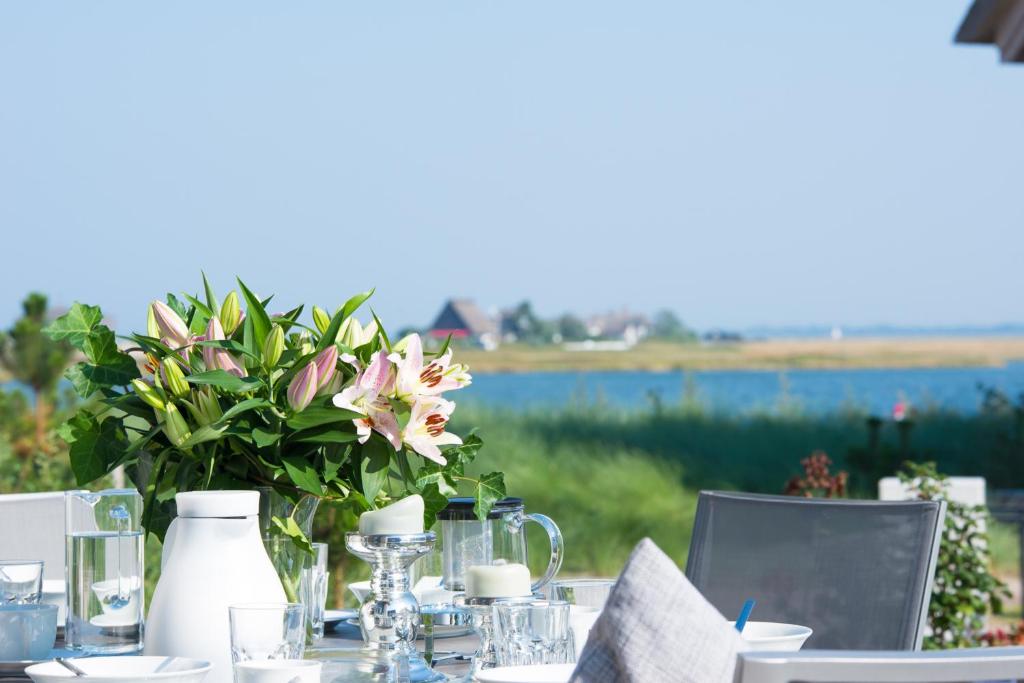 a table with a vase of flowers on it at Ostsee - Reetdachhaus Nr 38 "RIKE" im Strand Resort in Heiligenhafen