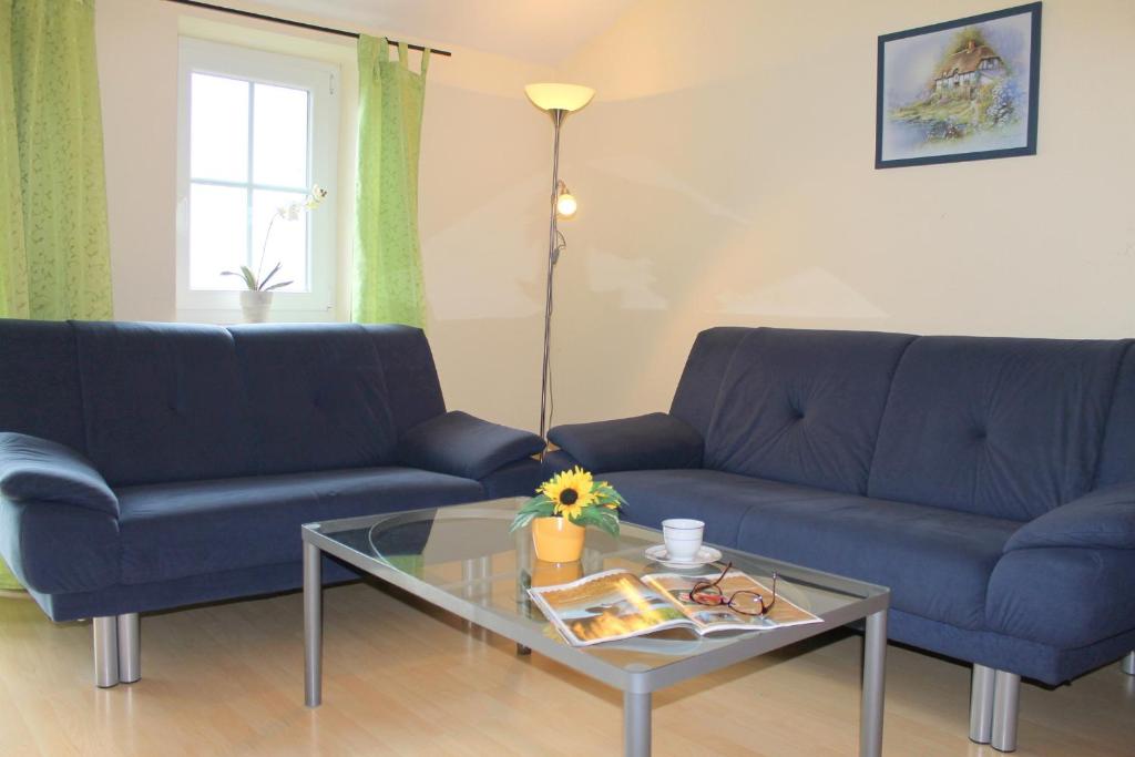 a living room with two blue couches and a glass table at "Hof Triangel - Whg 2" - Bauernhofurlaub in Riepsdorf