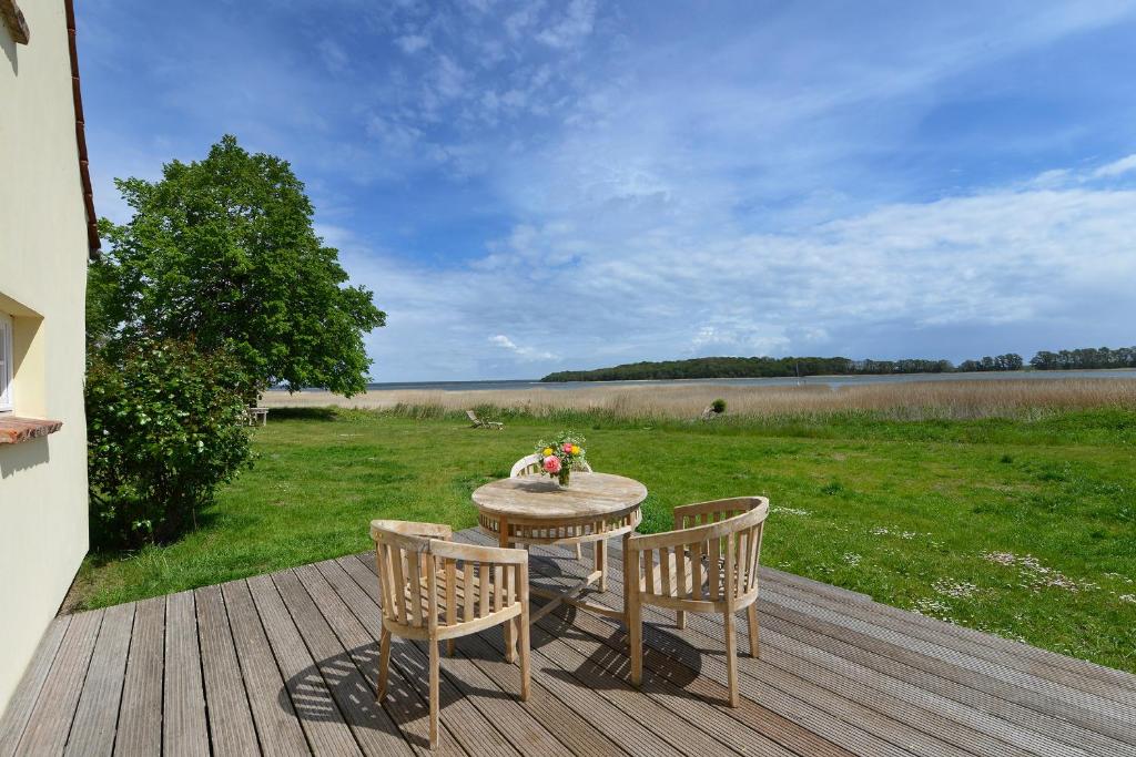 a table and chairs on a deck with a view of a field at Ferienhaus Remise 6 Personen mit Terrasse in Neuenkirchen