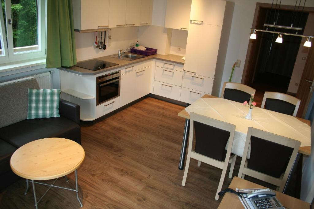 バート・ウィーゼにあるSemmelbergの白いキャビネット、テーブルと椅子付きのキッチンが備わります。