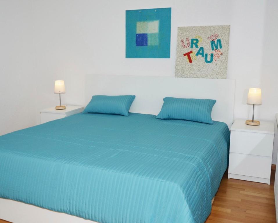 エッカーンフェルデにあるKunst&Handwerkのベッドルーム1室(青いベッド1台、ナイトスタンド2台付)