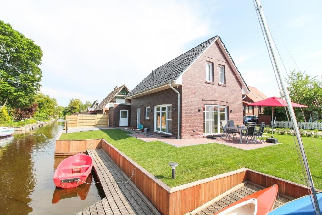 una casa en el agua con un barco dentro en Ferienhaus "Auf hoher See", en Südbrookmerland