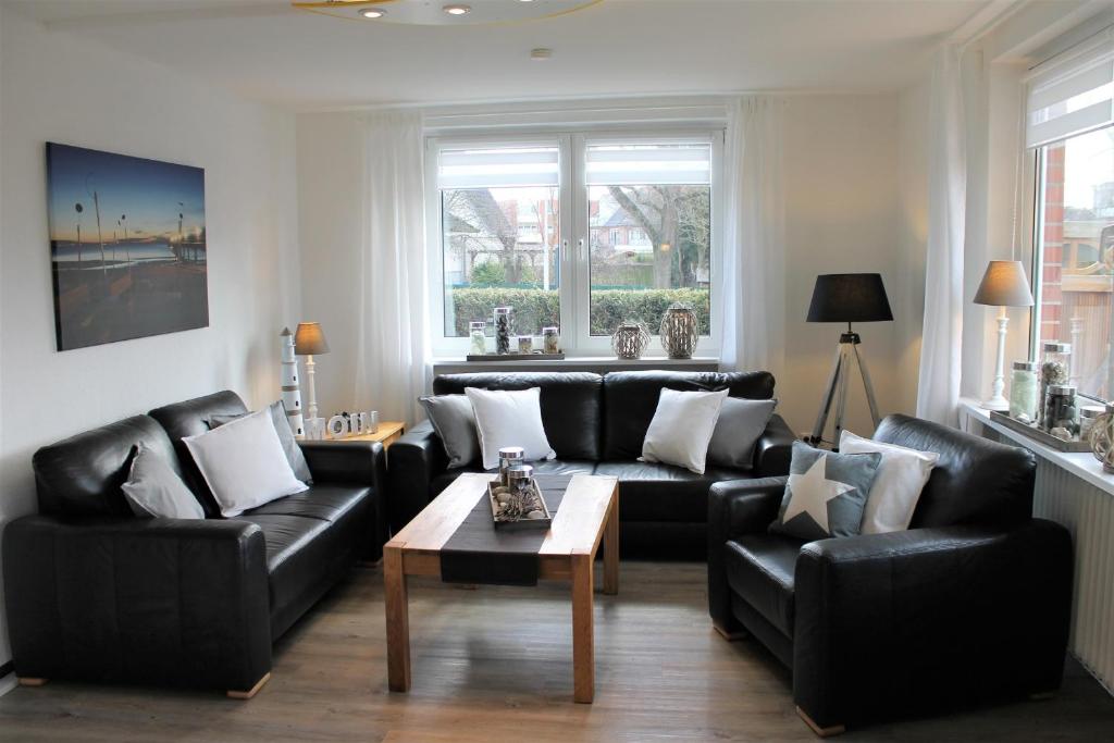 uma sala de estar com sofás de couro preto e uma mesa de centro em "Ferienhaus Sternchen" für die große Familie em Grömitz