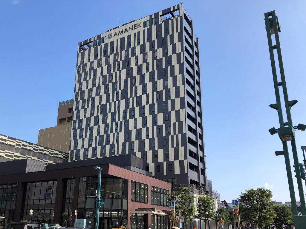 een hoog gebouw op de hoek van een straat bij HOTEL AMANEK Asahikawa in Asahikawa