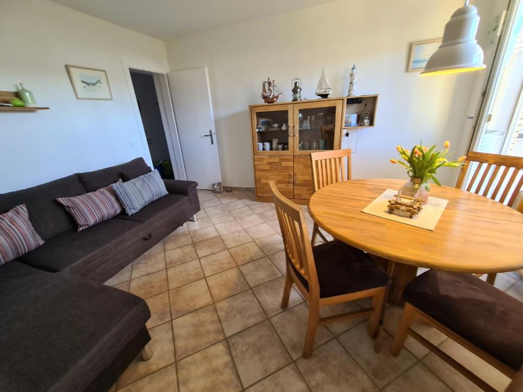 ein Wohnzimmer mit einem Tisch und einem Sofa in der Unterkunft Ferienwohnung Rosenthal in Grömitz