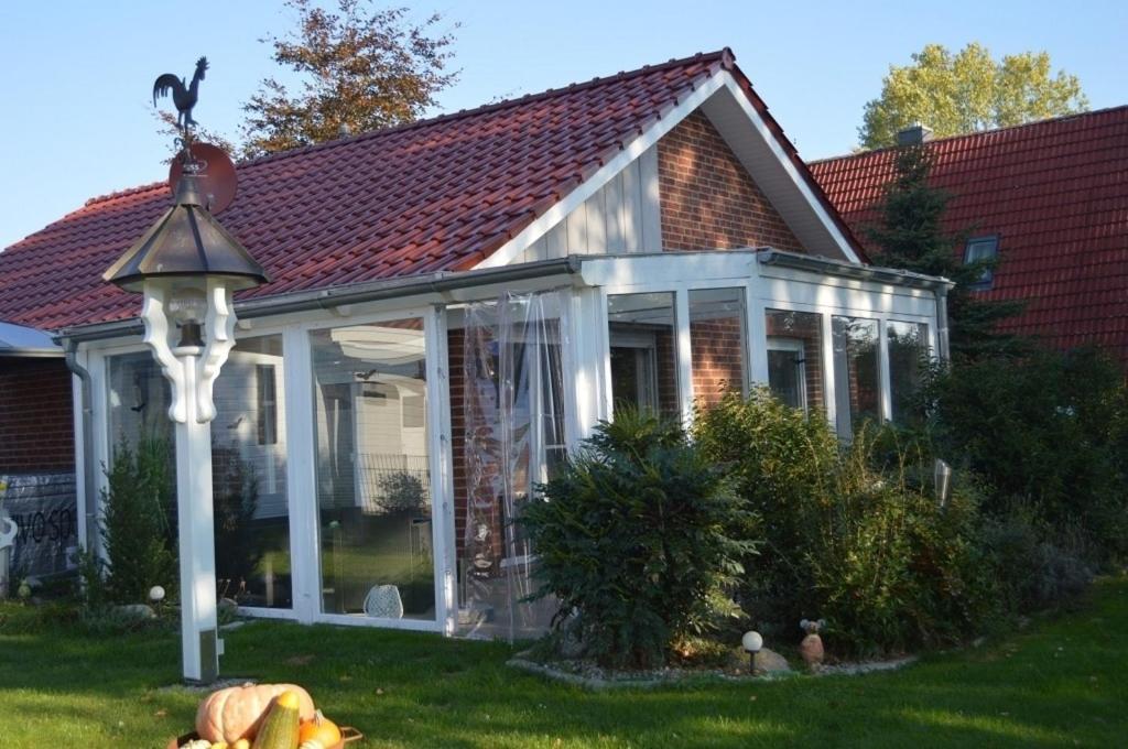 ein Haus mit Wintergarten mit Dach in der Unterkunft Haus Storchennest in Wiefelstede