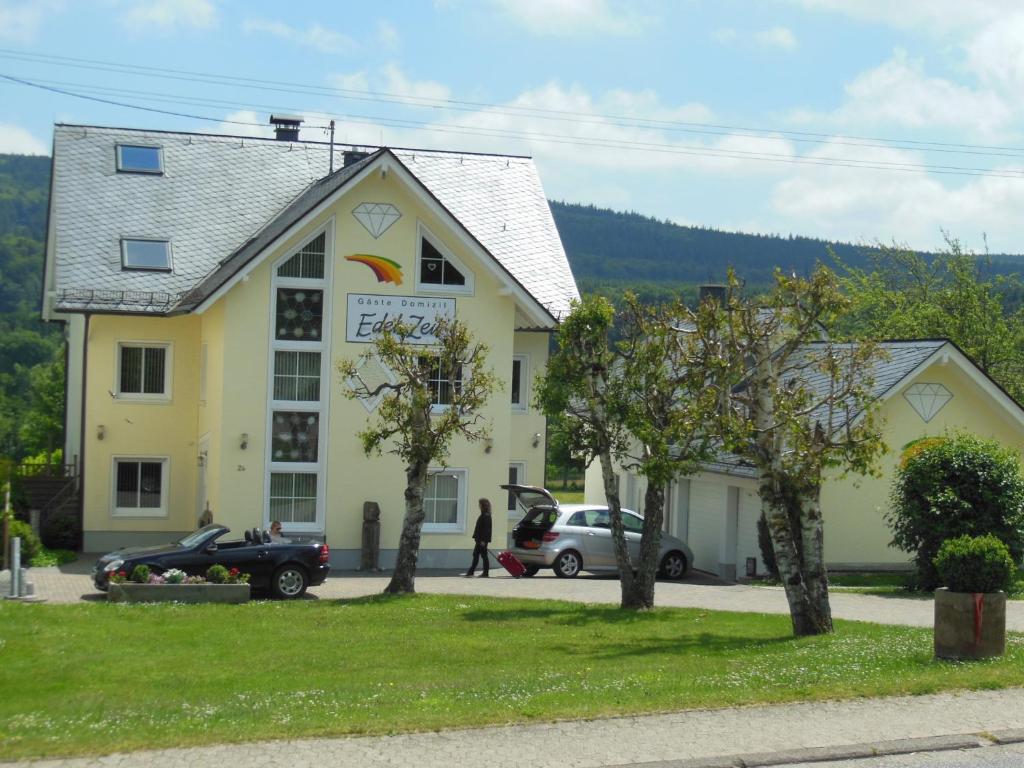 un edificio amarillo con un coche aparcado delante de él en 5-Sterne-Fewo "Brillant" en Allenbach